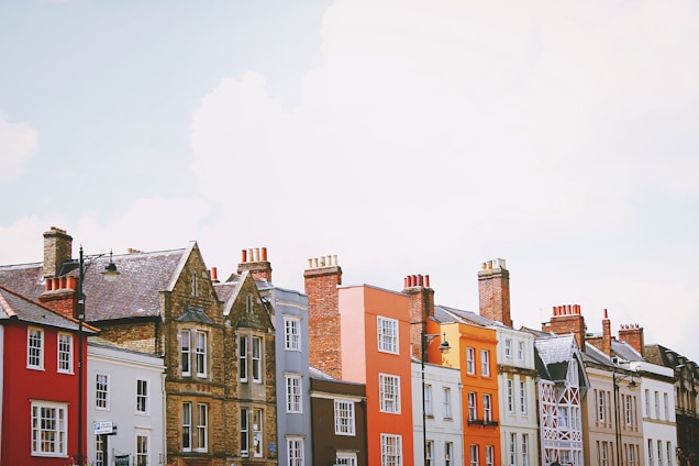 assorted-color concrete houses under white clouds during daytime