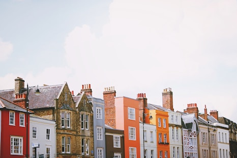 assorted-color concrete houses under white clouds during daytime