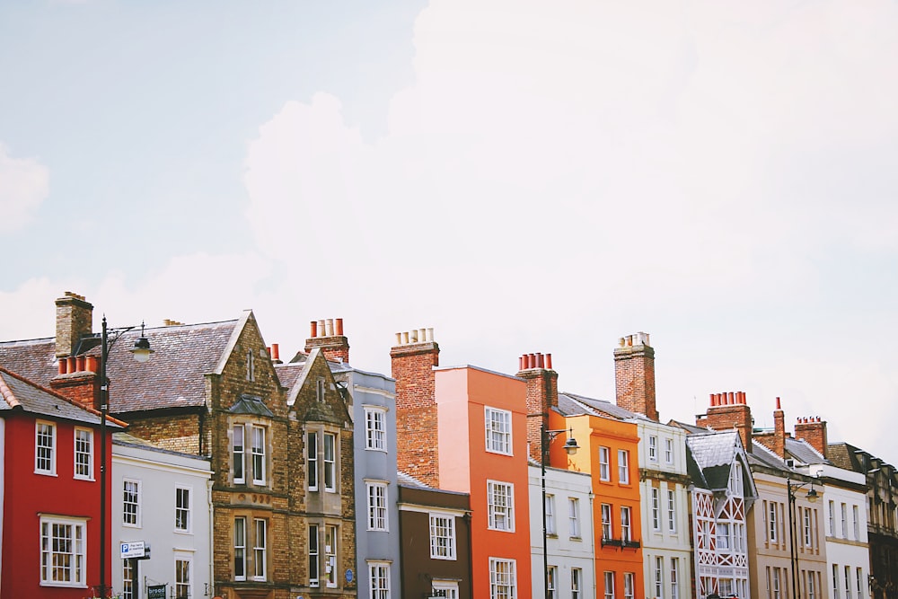 Casas de hormigón de colores variados bajo nubes blancas durante el día