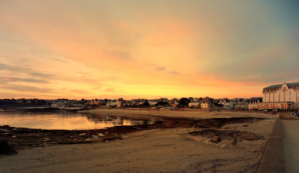 A serene sunset over a peaceful coastal village, symbolizing the calm of retirement abroad.