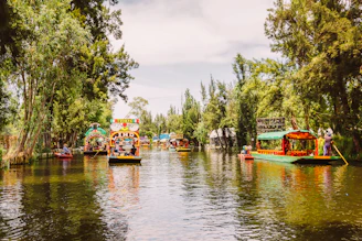 A colorful trajinera floating on Xochimilco canals surrounded by blooming water lilies and an axolotl swimming beneath.