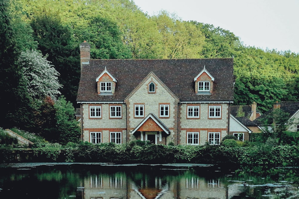 casa di cemento vicino a uno specchio d'acqua e foresta