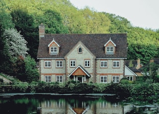 concrete house near a body of water and forest