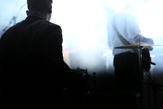 Silhouetted band members against a dark, misty backdrop.