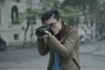 shallow focus photography of man taking photograph holding his camera