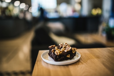 A happy person enjoying a brownie in a cozy café setting.