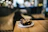 Close-up of a smiling woman enjoying a decadent chocolate brownie in a cozy, softly lit bakery setting.