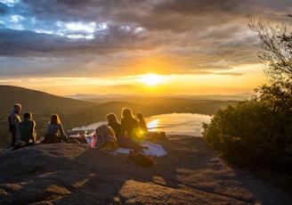 group of people sirring under sunset