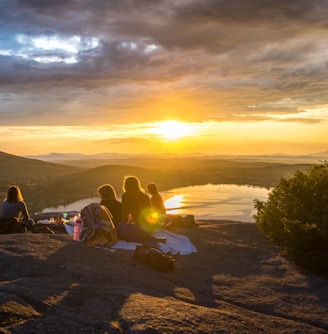 group of people sirring under sunset