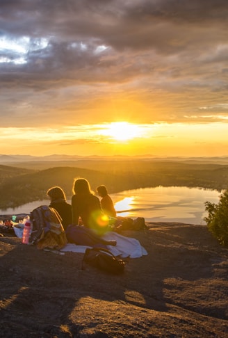 group of people sirring under sunset