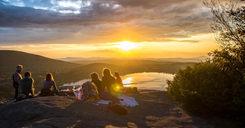 group of people sirring under sunset