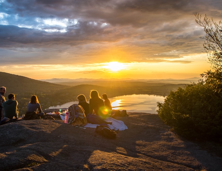 group of people sirring under sunset