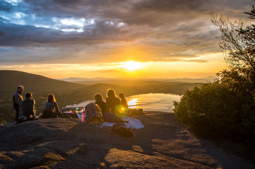 group of people sirring under sunset