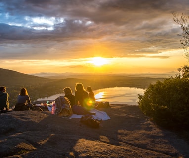 group of people sirring under sunset