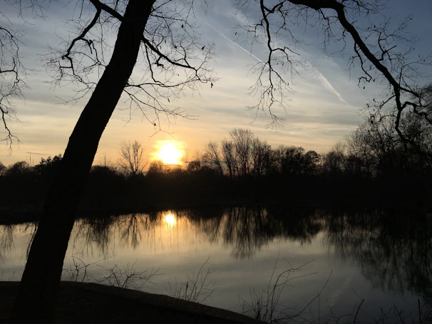 A peaceful sunset over a quiet lake, evoking a sense of spiritual calm and reflection.