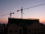 Construction site with cranes and emerging building structures at sunset