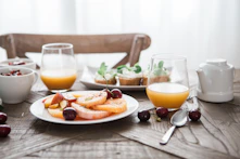 slice fruits on plate on near glass cups
