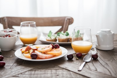 slice fruits on plate on near glass cups food styling google meet background