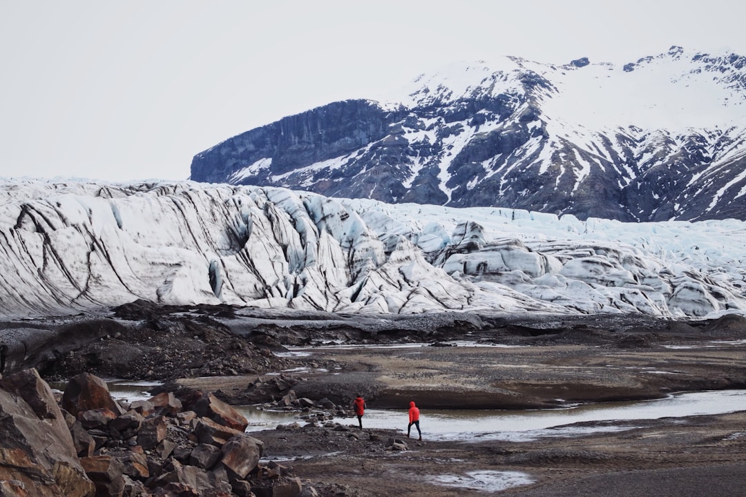 two persons standing near mountain