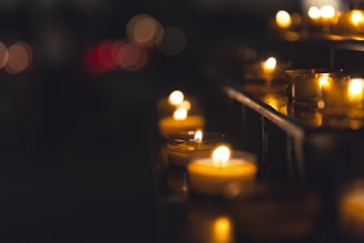 Artful arrangement of hand-crafted tealight holders casting intricate shadows on a wooden table.