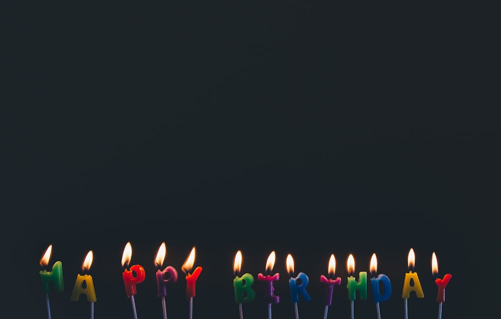 velas de feliz aniversário de cores variadas com chamas