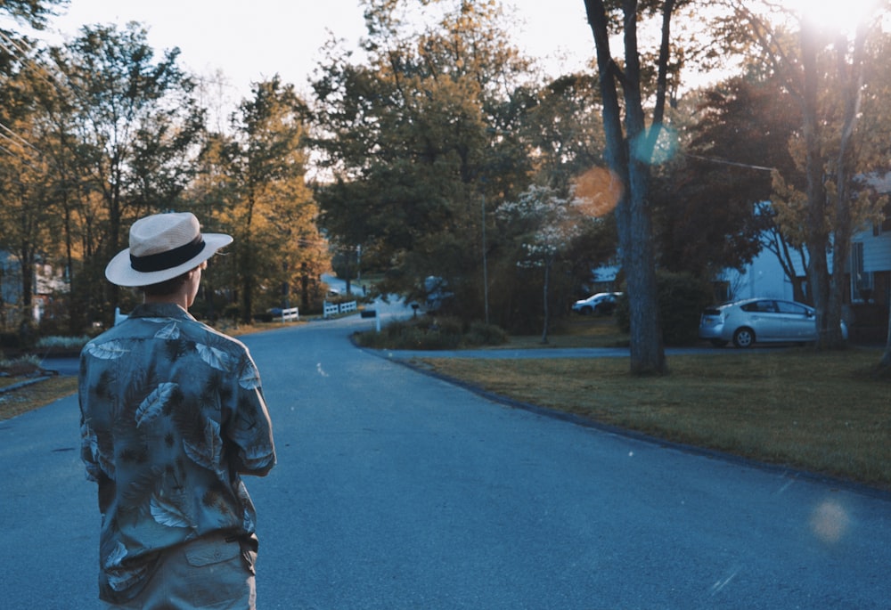 a man in a hat is walking down the street