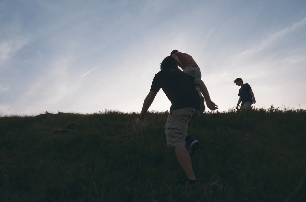 a group of people standing on top of a lush green field