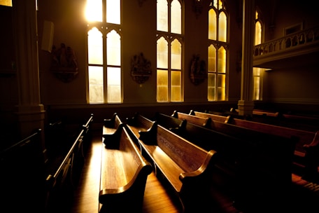 A warm, inviting church office with sunlight streaming through stained glass windows.