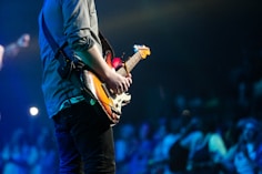 selective focus photography of man playing electric guitar on stage