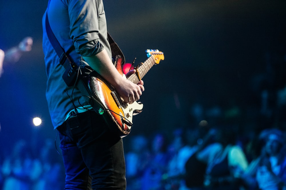 무대에서 일렉트릭 기타를 연주하는 남자의 선택적 초점 사진