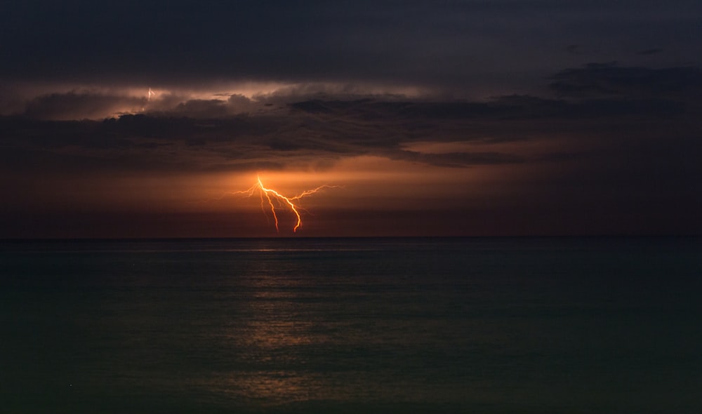 lightning in ocean during night time