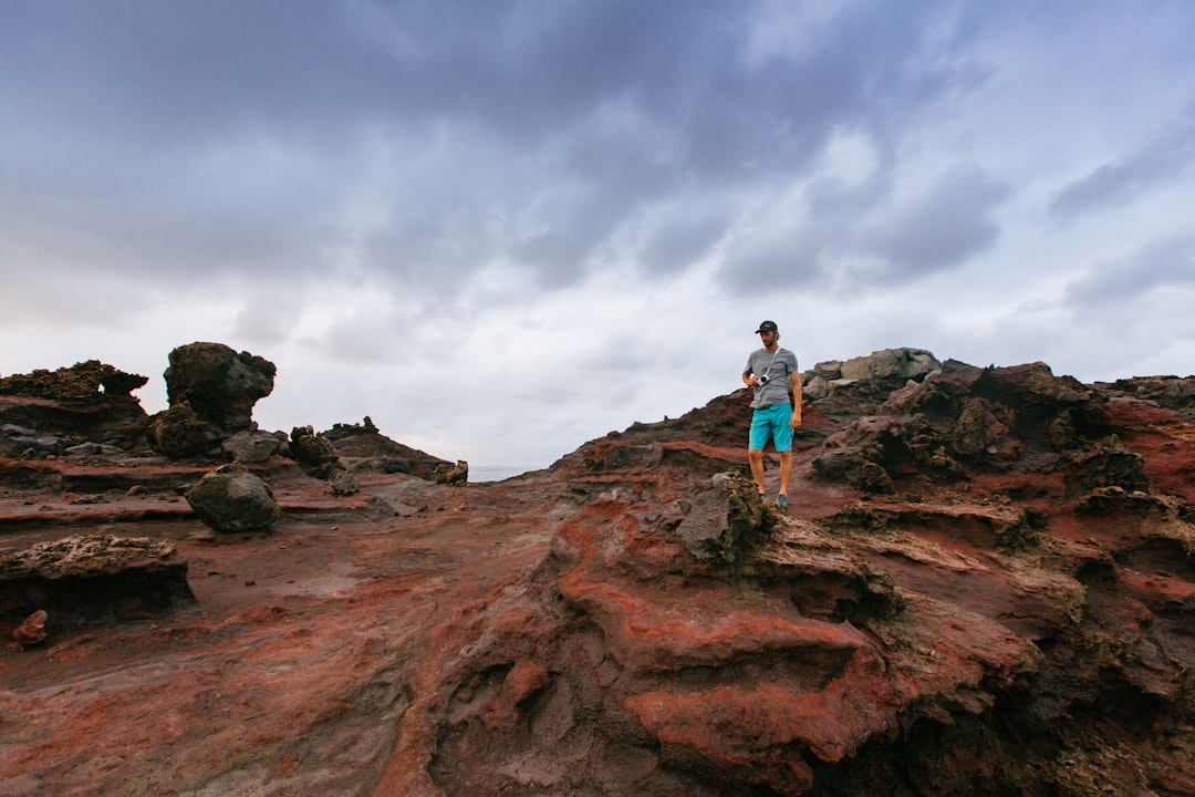 person standing on top on boulder,
