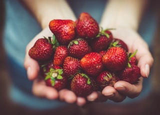 shallow focus photography of strawberries on person's palm