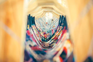 Display of colorful water wave basic clothes hanging against a backdrop of tropical artwork