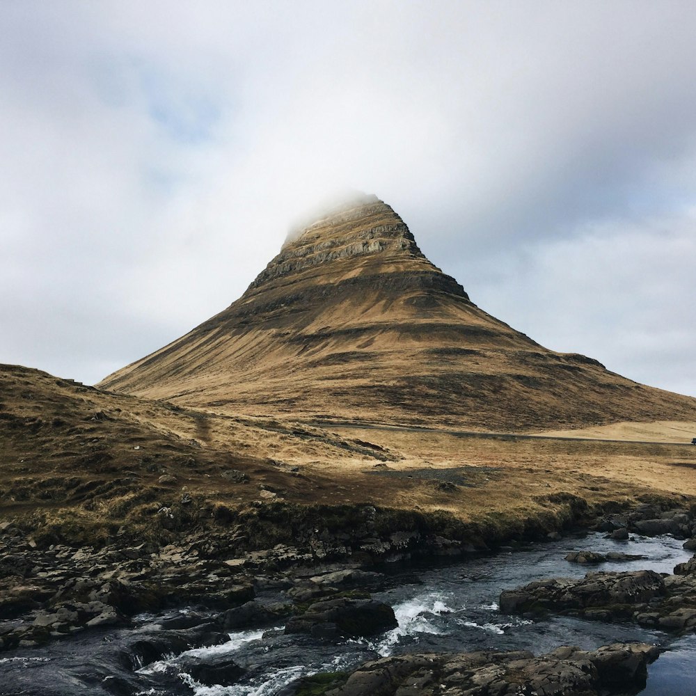 brown mountain covered by clouds