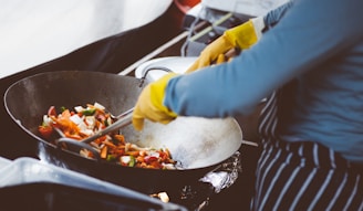 person mixing vegetable in wok