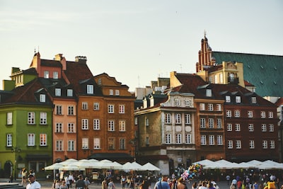 group of people on street near the brown concrete building poland google meet background