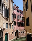 Scenic canals of Ghent with historic buildings reflecting in the calm water on a bright day.