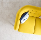 yellow fabric sofa with throw pillow