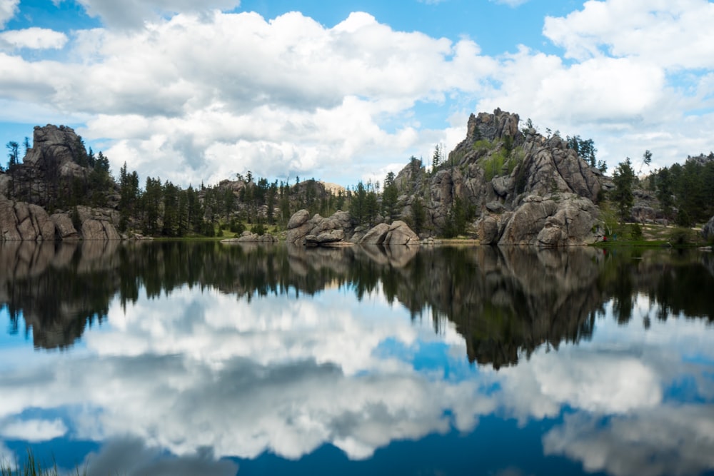 photography of body of water near mountain at daytime