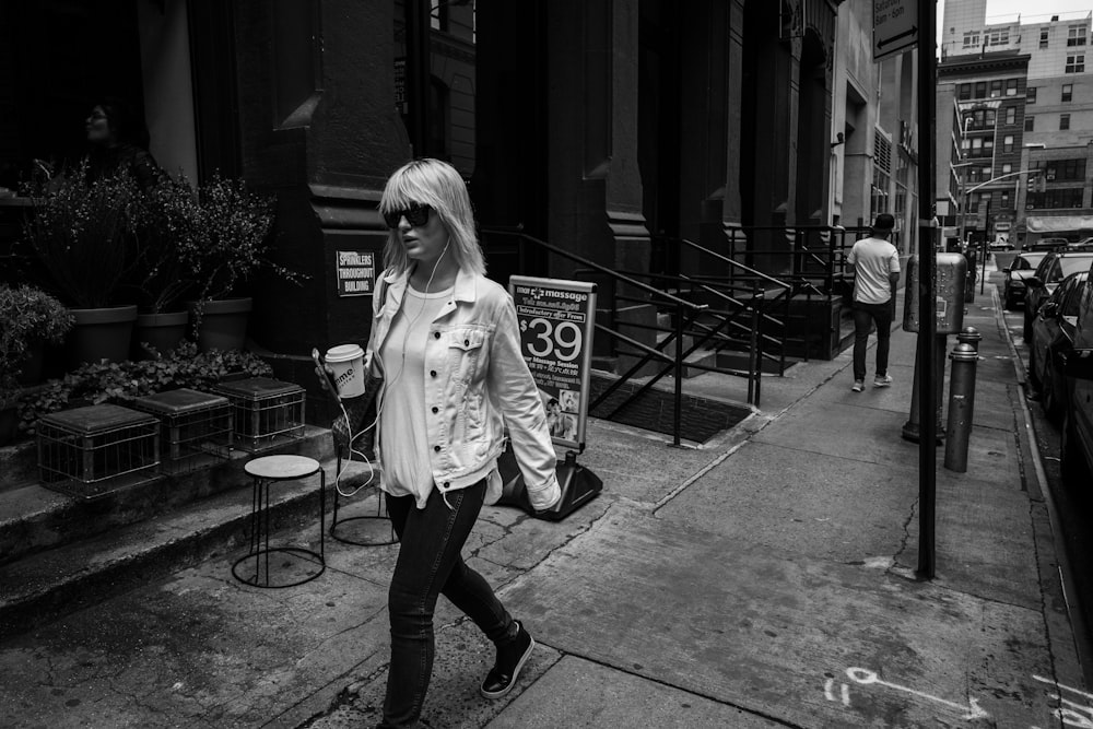 woman walking on pathway near concrete building