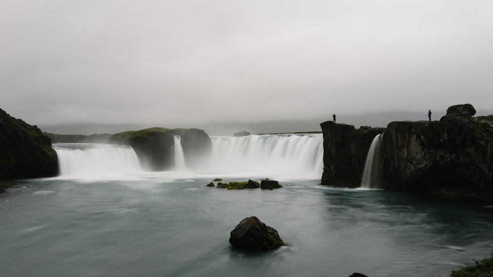 waterfalls under cloudy sky