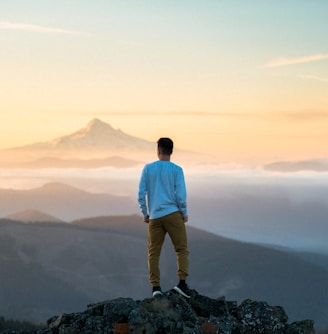 man standing on top of mountain