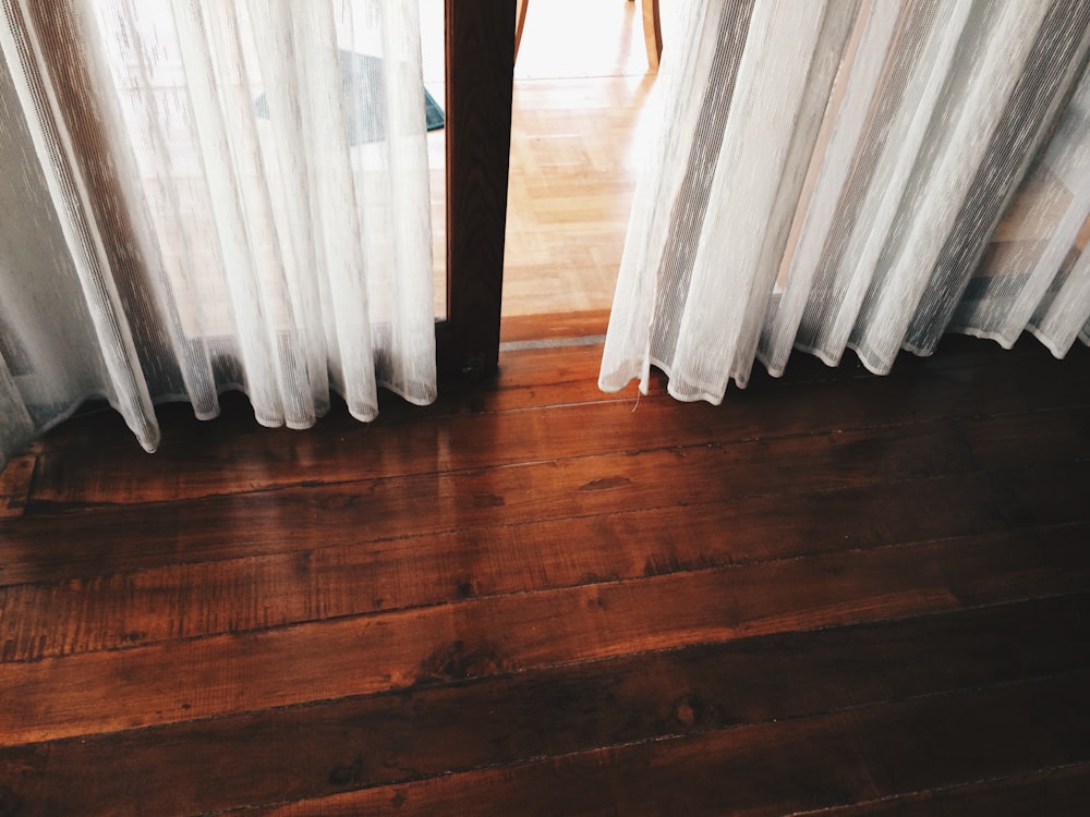 two white curtains covering a glass door