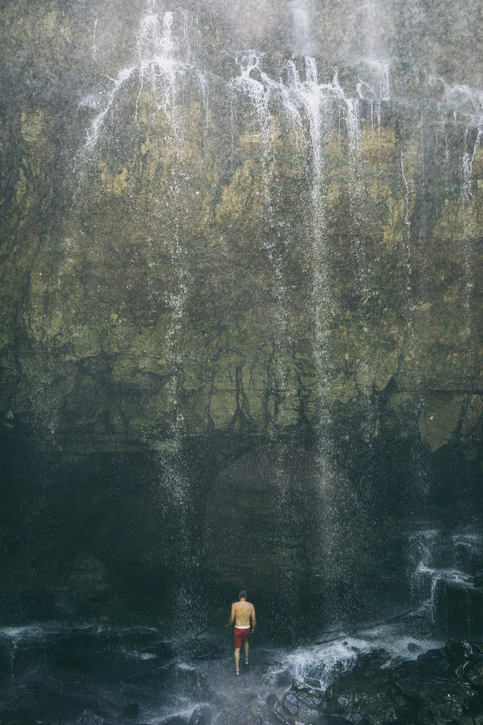 Sony Vario Tessar T* FE 24-70mm F4 ZA OSS sample photo. Man standing underneath waterfall photography