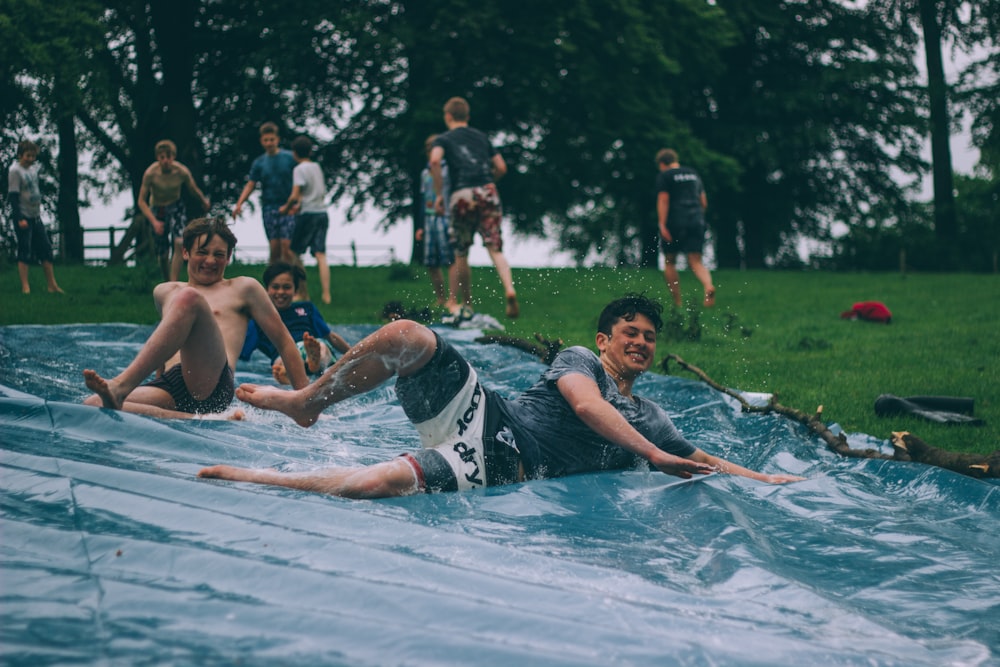 group of men sliding on blue canopy