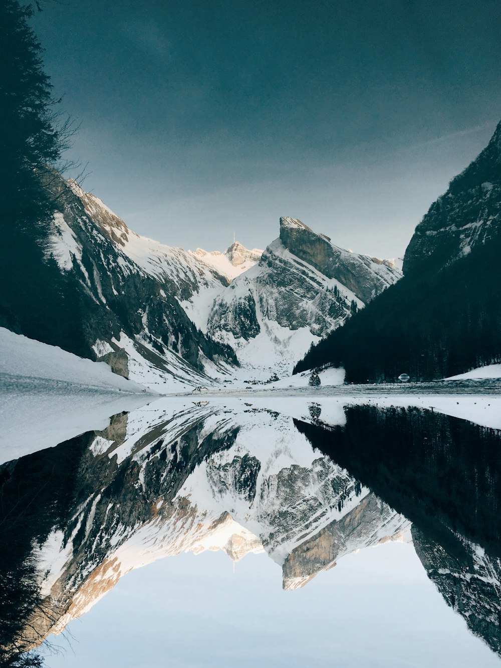 montagne enneigée près du lac sous le ciel bleu