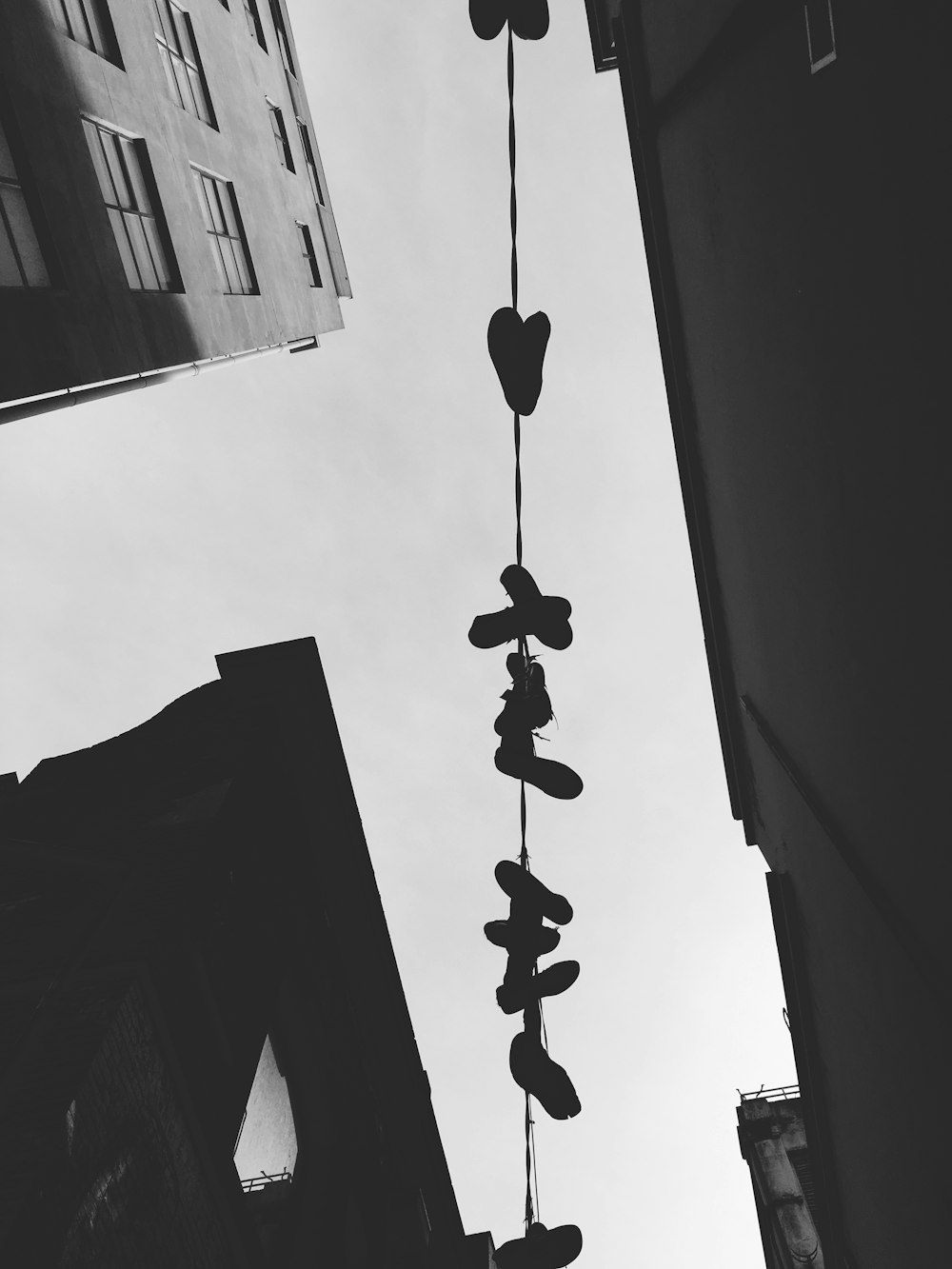 A clothesline with clothespins hung from large residential buildings.