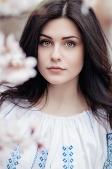 woman standing near white petaled flower