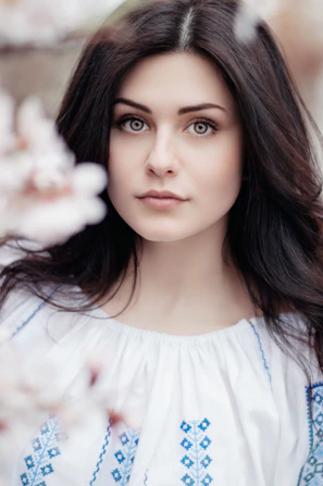 woman standing near white petaled flower